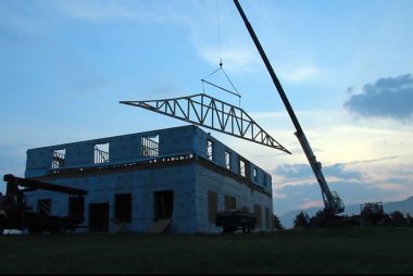 Raising the first roof truss of the temple.