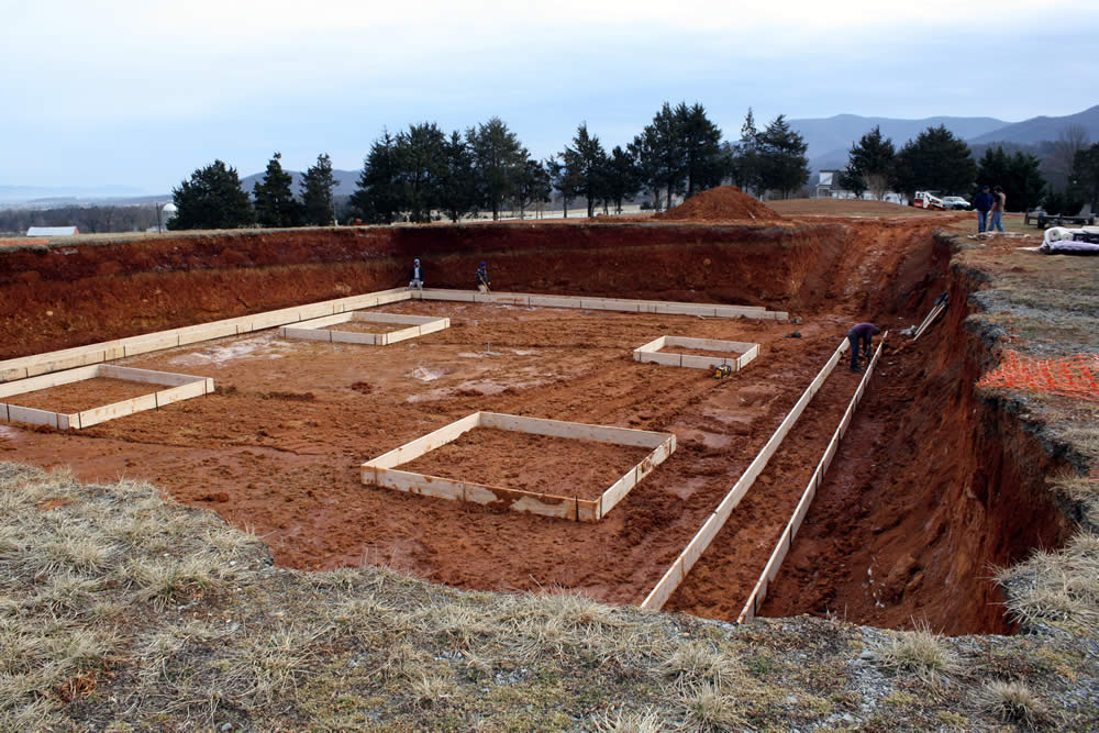 By twilight work on the footers (around periphery) and piers (square areas) has progressed.