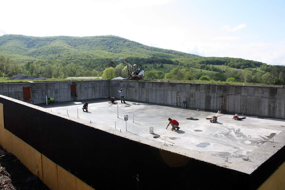 Once the concrete has dried sufficiently, workers check and touch up the surface of the new concrete floor.